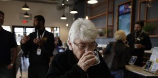 Sandy Sopher, de 65 años, huele un botón de marihuana en el dispensario Bud and Bloom de Santa Ana, California, el 19 de febrero del 2019. Cada vez más ancianos apelan a derivados de la marihuana para tratar problemas médicos en EEUU. (AP Photo/Jae C. Hong)