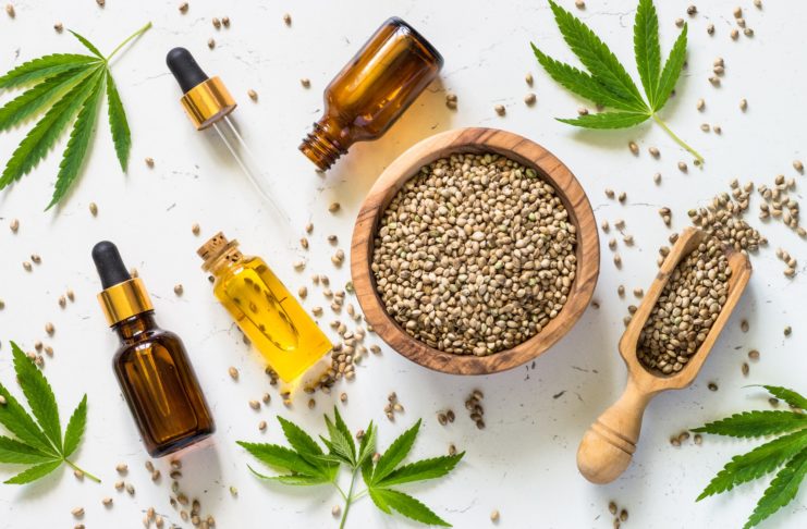 Cannabis oil and cannabis seeds at white