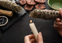 Qué significa para el turismo en México la legalización del cannabis y la creciente industria del wellness Cropped view of shaman holding candle and smudge stick near witchcraft on black wooden background