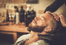 Hairstylist washing client's hair in barber shop