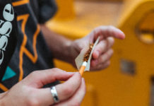 Unidas Podemos reivindica su ley del cannabis para “luchar contra la despoblación” y recaudar 3.000 millones al año Anonymous guy rolling up joint on street