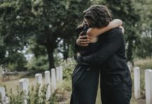 ¿Puede la MDMA ayudar con el duelo y la pérdida emocional? Husband trying to comfort his wife at a graveyard
