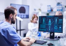 Young technician typing data for human body neurology system in science laboratory