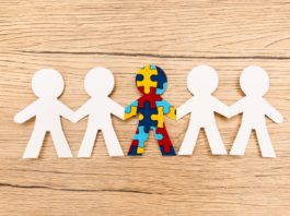 Top view of special kid with autism among another on wooden background