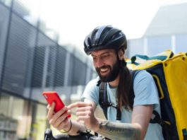 Portrait of food delivery man with mobile phone
