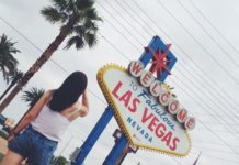 A girl standing in front of Welcome to fabulous Las Vegas sign, Las Vegas, Nevada, The USA