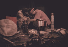 shaman or sorcerer men giving sangha medicine, ayahuasca, during prehispanic ritual on black background