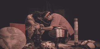 shaman or sorcerer men giving sangha medicine, ayahuasca, during prehispanic ritual on black background
