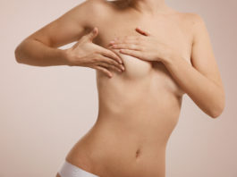 Breast cancer concept - woman checking her breast.