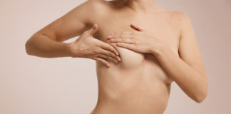 Breast cancer concept - woman checking her breast.