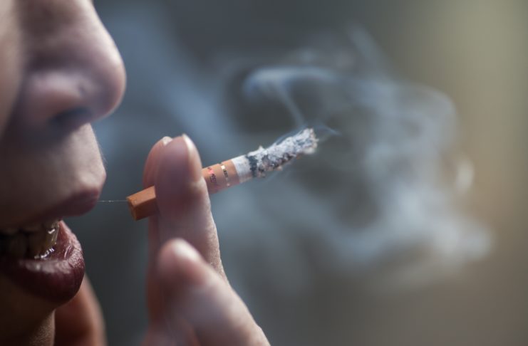 Closeup shot of a Chinese female smoking a cigarette