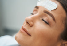 Woman with facial cream on her forehead