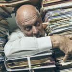 Panicked businessman overloaded with paperwork