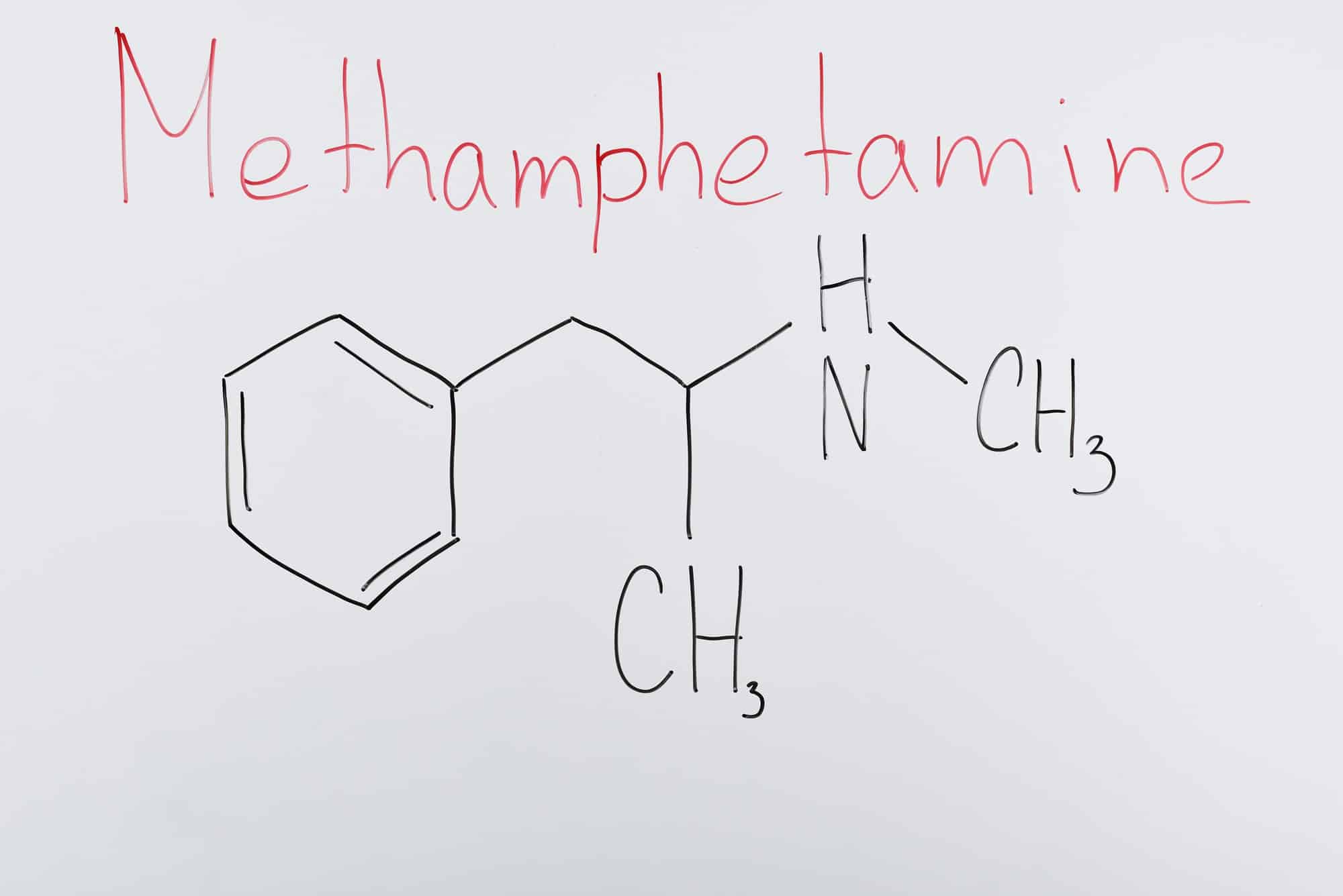 top view of white board with chemical formula and lettering methamphetamine