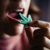 Cbd candy - Woman eating edible cannabis leaf for anxiety treatment - Marijuana alternative medicine