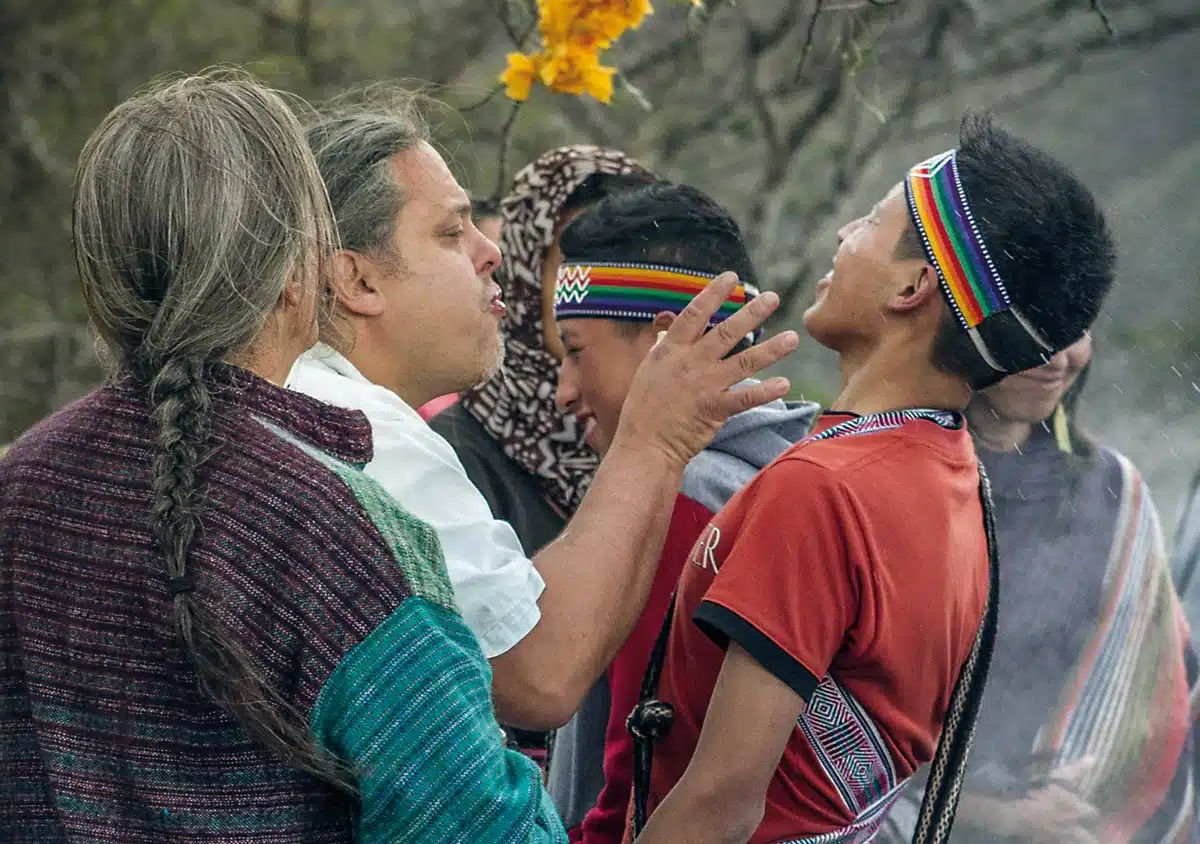 Taita Alejo y Juan soplando en e rezo de la cuarta danza