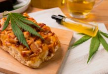 Pizzería en Wisconsin se disculpa tras servir accidentalmente pizzas con cannabis Homemade pizza with marijuana or cannabis leaf on wooden tray.