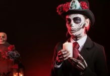 Woman lighting candle for magic ritual in graveyard, celebrating Day of the Dea