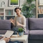 a-woman-sitting-on-a-couch-talking-to-a-man-stockpack-unsplash