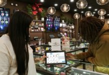Alabama supera los 100 pacientes en la primera semana de ventas Budtender is sharing a POS tablet with product information with consumers. Hip to hip interaction.