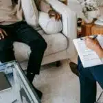 La psilocibina mantiene mejoras a 12 meses en depresión resistente en EPIsoDE Crop unrecognizable black man sharing complains with female psychologist