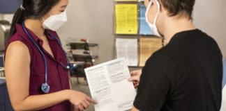In this 2020 photograph, captured inside a clinical setting, a health care provider and patient, consult on influenza vaccine options. The best way to prevent seasonal flu illness, is to get vaccinated every year. Centers for Disease Control and Prevention (CDC) recommends everyone 6-months of age and older get a flu vaccine every season. There are many vaccine options to choose from, but the most important thing, is for all people 6-months and older, get an influenza vaccine every year.