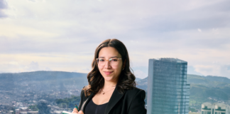 Confident businesswoman with notebook in urban skyline