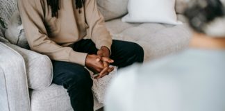 Crop ethnic man having conversation with psychologist