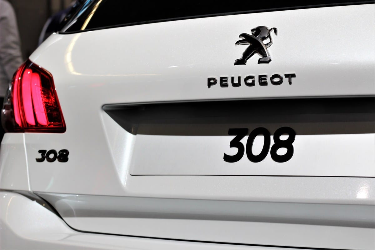 Detalle trasero de un Peugeot 308 blanco con el piloto izquierdo encendido