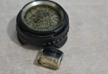 Cómo preparar y vaporizar extractos personalizados Cazoleta circular con malla metálica y pequeño recipiente de vidrio con restos de extracto