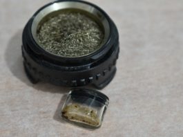 Cómo preparar y vaporizar extractos personalizados Cazoleta circular con malla metálica y pequeño recipiente de vidrio con restos de extracto