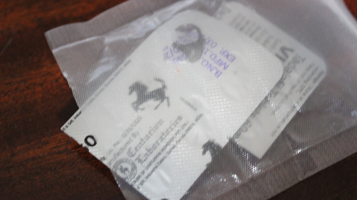 Dos sobres plateados con texto impreso y siluetas de animales dentro de una bolsa transparente