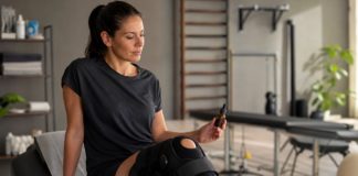 Persona en rehabilitaci&oacute;n por una fractura de meseta tibial con la rodilla apoyada y un frasco de aceite de CBD sin marca