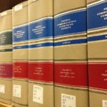 Volúmenes encuadernados de informes jurídicos alineados en una estantería