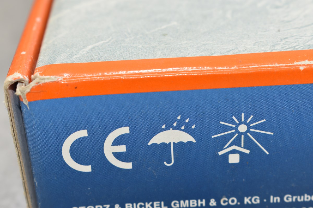 S&iacute;mbolo CE e iconos de protecci&oacute;n contra lluvia y sol impresos en una caja