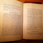 Libro abierto con descripciones en español de Cannabis indica y Cannabis sativa sobre una mesa de madera
