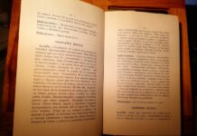 Libro abierto con descripciones en español de Cannabis indica y Cannabis sativa sobre una mesa de madera