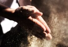 Cáñamo alimentario: cómo incorporarlo a la dieta Manos frotándose mientras desprenden una nube de polvo fino iluminada por el sol