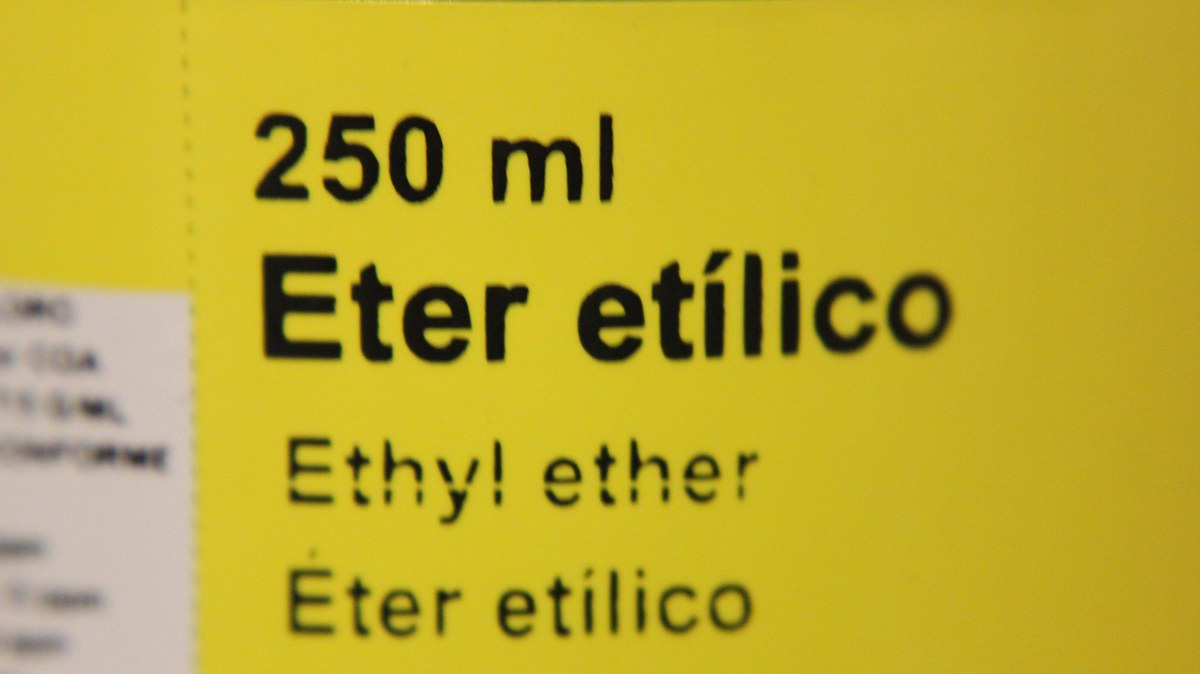 Detalle de una etiqueta amarilla con el texto &laquo;250 ml &Eacute;ter et&iacute;lico&raquo; en varios idiomas