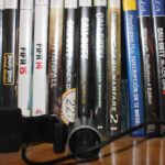 Estuche con videojuegos de consola, una cámara y accesorios sobre una mesa de madera