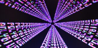 Videojuegos y alucinaciones: de Polybius a Hellblade Filas de la palabra «PLAY» en tonos magenta, azul y blanco convergen hacia el centro sobre un fondo negro.
