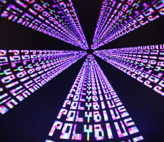 Videojuegos y alucinaciones: de Polybius a Hellblade Filas de la palabra «PLAY» en tonos magenta, azul y blanco convergen hacia el centro sobre un fondo negro.