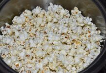 Edibles cannábicos frente a la vaporización Palomitas de maíz recién hechas dentro de una olla metálica.