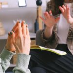 Plano de manos y cuadernos durante una conversaci&oacute;n en una consulta, sin rostros visibles