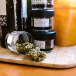 Envases con flores de cannabis regulado sobre una tabla de madera