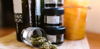 Envases con flores de cannabis regulado sobre una tabla de madera
