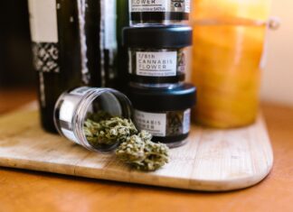Envases con flores de cannabis regulado sobre una tabla de madera