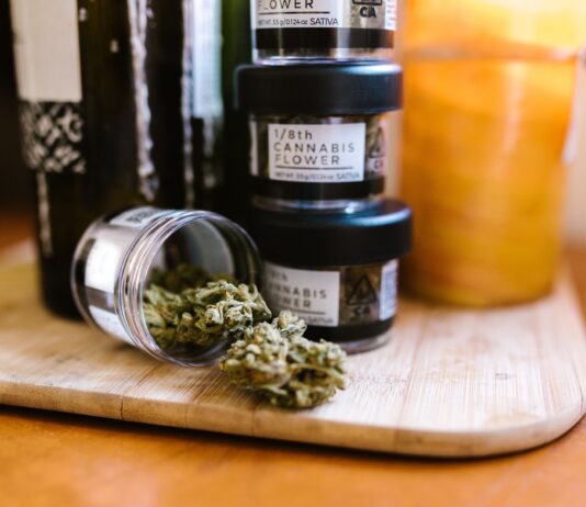 Envases con flores de cannabis regulado sobre una tabla de madera