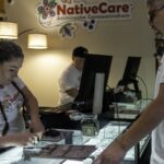 Una empleada registra una compra de cannabis junto a un cliente en el mostrador de NativeCare, Minnesota, en una fotografía de archivo de 2023