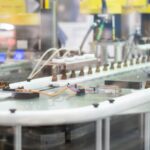 Una línea automatizada transporta pequeños frascos de vidrio ámbar en una instalación de fabricación